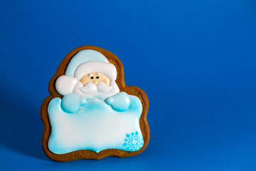 gingerbread cookie of Santa's with copyspace on blue background. Traditional Christmas food. Christmas and New Year holiday concept.