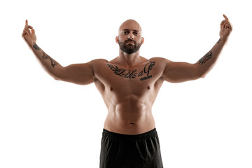 Fototapeta premium Athletic bald, tattooed man in black shorts is posing isolated on white background. Close-up portrait.