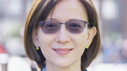Portrait of smiling Asian female wearing glasses looking to camera 