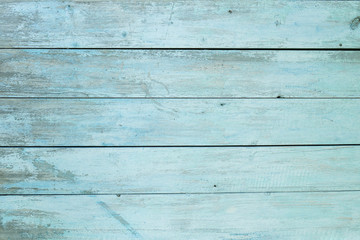 Fototapeta na wymiar old wooden fence light blue paint peeling board texture. Background