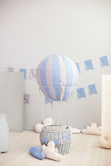 Bright children's room with a balloon, balloons and textile clouds on a white wall background with holiday flags. Children bedroom. interior of kindergarten. Scandinavian room interior. Rustic decor