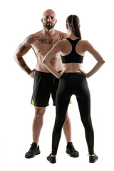 Athletic man in black shorts and sneakers with brunette woman in leggings and top posing isolated...