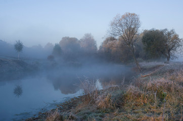 Naklejka na ściany i meble autumn morning, the first frosts, fog over the lake.