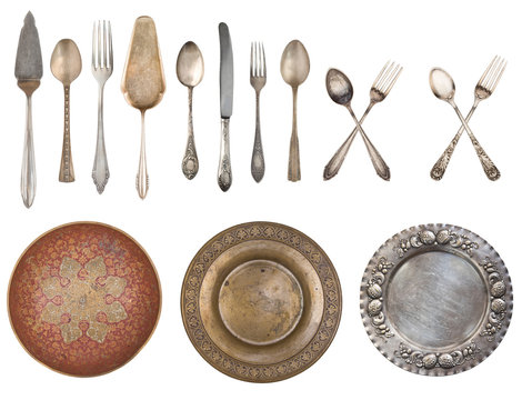 White plates and vintage spoons and fork on color wooden background