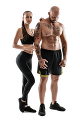 Obraz na płótnie Canvas Athletic man in black shorts and sneakers with brunette woman in leggings and top posing isolated on white background. Fitness couple, gym concept.