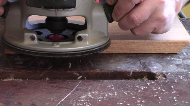 Person Milling With Round Over Bit Using A Router On Oak Board