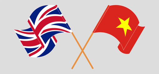 Crossed and waving flags of Vietnam and the UK