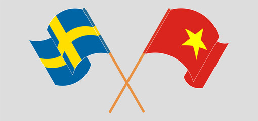 Crossed and waving flags of Vietnam and Sweden