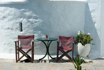 Greece - Amorgos island. A small square with chapels and taverna tables and chairs