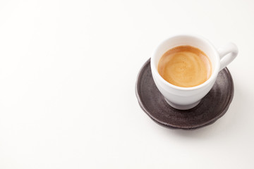 Cup of coffee on white paper background. Close up. Copy space.