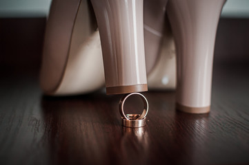 Pair of high heel shoes and gold wedding rings