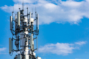 A closeup and detailed view of various GPS, cellphone, 3G, 4G and 5G equipped telecommunication tower as seen on cloudy blue sky with copy space