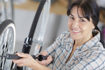 a woman inflating bike wheel