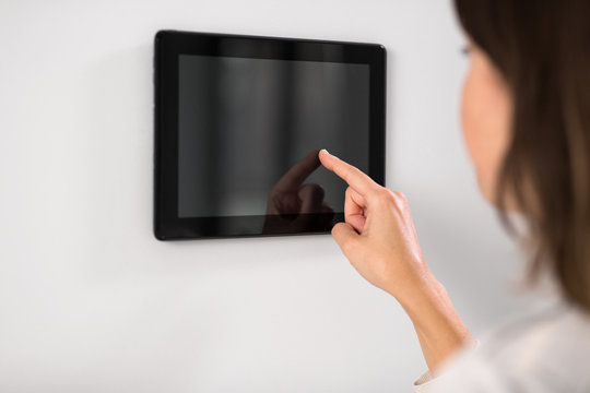 automation, internet of things and technology concept - woman using tablet pc computer at smart home
