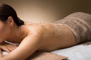 wellness, beauty and relaxation concept - close up of beautiful young woman with sea salt on skin...