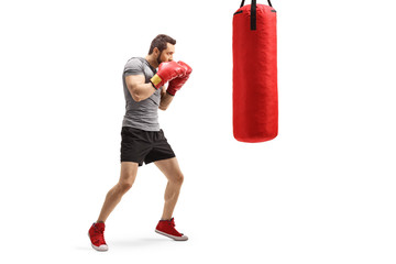 Young fit man training box with a punching bag