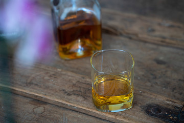Golden whisky in glass and bottle on an old barrel with nice reflection
