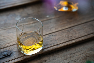 Close up of whisky glass on an original rustic barrel