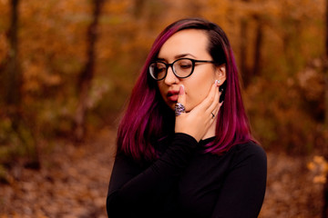 young girl with glasses posing in autumn forest