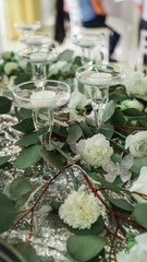 candles in a glass at a wedding with flowers on the table