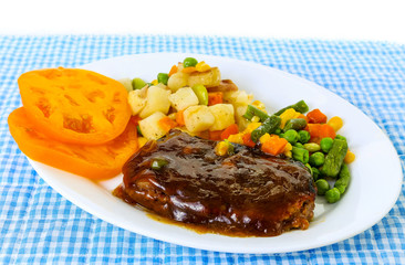 Brown gravy over chopped steak microwave dinner with new potatoes and vegetable medley.
