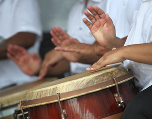 Hands playing puerto rican folk music in a typical latin drums - obrazy, fototapety, plakaty