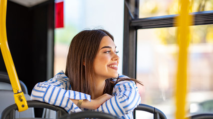 Woman traveler contemplating outdoor view from window of bus. Young lady on commute travel to work...