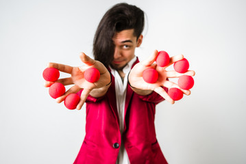 Juggler placing red balls between his fingers for fun and economic tricks.