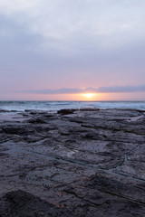 Cloudy sunrise view in the rocky coastline.