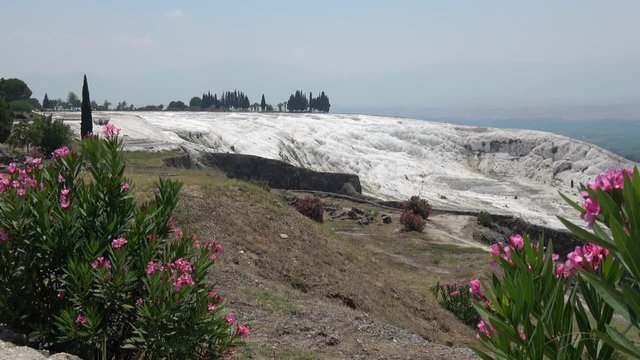Pamukkale, Denizli, Turkey - 16th of July 2019: 4K Zoom out sinter terraces above valley