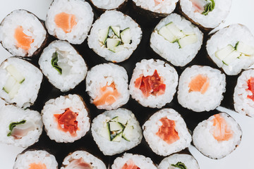 Top view of sushi maki rolls with salmon and cucumber and other ingredients