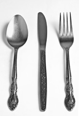Vintage spoon, knife and fork on a white background.