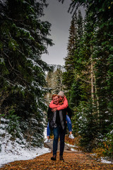 young couple exploring winter forest mountains