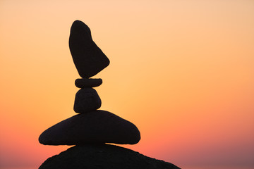 balanced stones on the beach at sunset