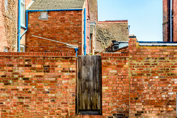 old wooden door gate in red brick wall in england town