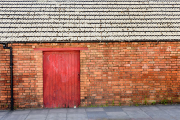 old wooden door gate in red brick wall in england town