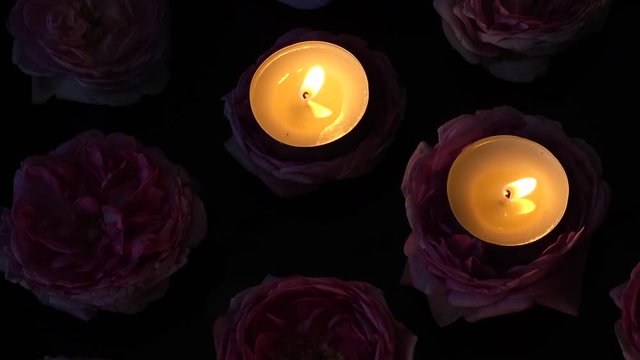 Roses and candles on a black background.