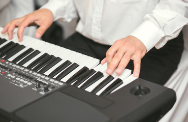 Hands of male musician playing at synthesizer. Mens arms plays solo of music or new melody. Close up fingers of pianist at the piano keys. Slow motion Top view.