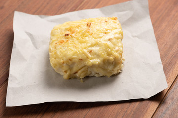 Traditional Croque Monsieur  toasted with cheese and ham topped with bechamel sauce on wooden background
