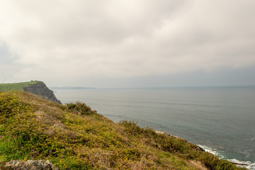 Fototapeta premium Cliffs in the sea with a cloudy sky. Cantabrian coast in the Atlantic Ocean.