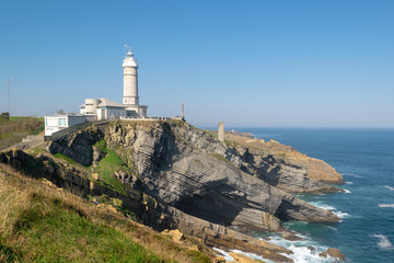 Fototapeta na wymiar Lighthouse of Cabo Mayor in Santander. Lighthouse on the cliff with the sea under.