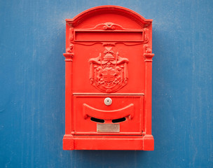 Bright red mail box on a blue background.