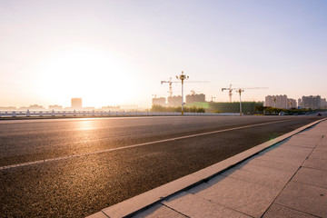 Asphalt road and beautiful blue sky in the background of sunrise