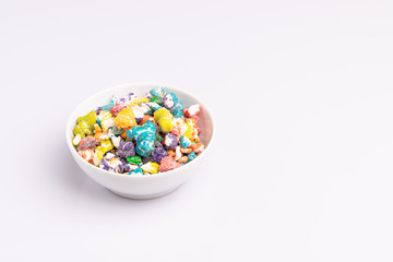 Colored Popcorn candy isolated on white background, soft light, studio shot, copy space. Junk food, fruit flavored popcorn. Colorful, multicolor, candy coated popcorn