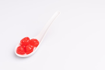 Maraschino cherry in a white bowl, isolated on white background, soft light, studio shot