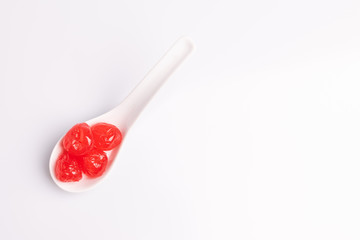 Maraschino cherry in a white bowl, isolated on white background, soft light, studio shot