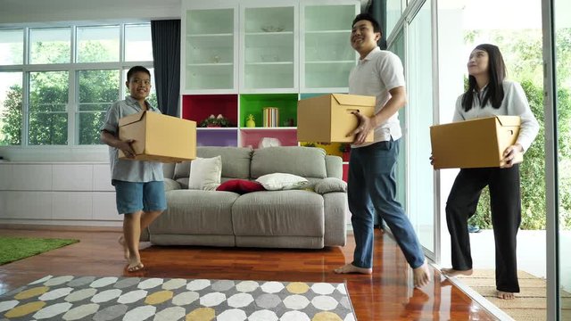 Happy Asian Family With Cardboard Boxes Walked Into In New House At Moving Day,  Moving House, First Home. Slow Motion