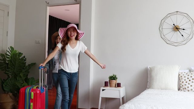 Two girl friends asian with suitcases Walked into the guesthouse or hostel in order to stay in a room and Lay down on the bed at home. trip holiday travel vacation.