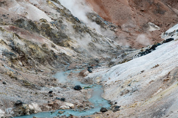 Jigokudani hell valley walking trail in Noboribetsu, Hokkaido, Japan. Selective focus at front banister of wooden footpath.