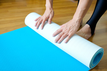 Women are yoga mat  blue rolls. Fitness room